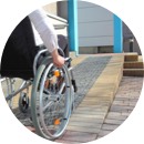 imagen de un señor en sillas de ruedas de espaldas frente a una rampa 